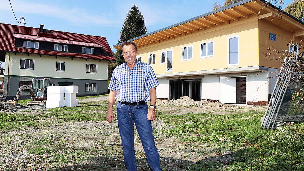 Erik Schinegger vor seinem neuen Wirtschaftsgebäude (rechts) und dem sanierten Gasthof