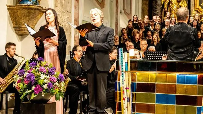 Stimmgewaltig die 90 Sängerinnen und Sänger der Chöre des KMV Hartberg, der Scholae Musici Cantores, dem Chor Voices Wides und dem Ensemble aerophonic, dazu ein großes sinfonisches Blasorchester sowie die Solisten Verena Fink (Sopran) und Franz Fahrleitner (Tenor), geleitet von Johannes Steinwender, war es ein tiefgehender musikalischer Abend. 