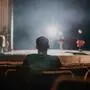 One spectator sitting and watching the rehearsal of ballet dancer on stage