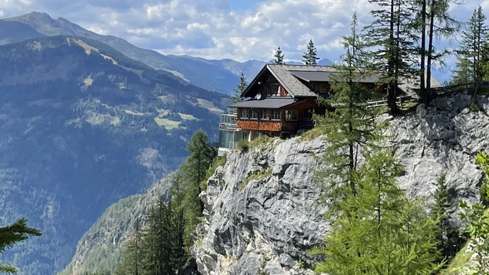 Die auf einem Felsvorsprung thronende Dolomitenhütte