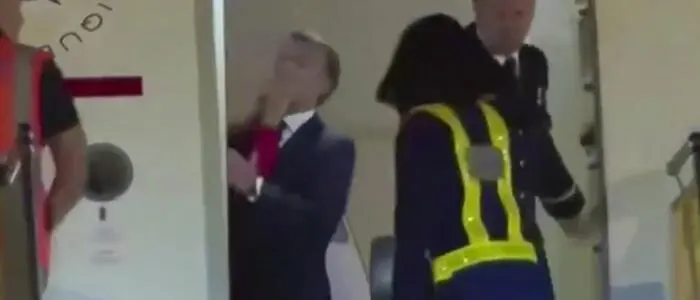 Emmanuel Macron, eine Mitarbeiterin des Flughafens in Hanoi und ein Mitglied der Crew der Präsidentenmaschine in der offenen Flugzeugtür | Der Moment, über den diskutiert wird: die Hand im Gesicht von Emmanuel Macron