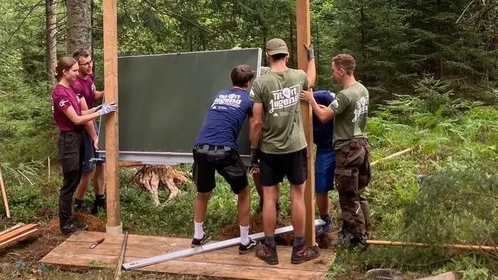 Sechs Personen errichten gerade eine Schautafel
