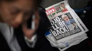 A copy of The Sun newspaper featuring former prime minister Boris Johnson lies on the floor outside 10 Downing Street in central London on October 21, 2022. - Contenders bidding to succeed Prime Minister Liz Truss canvassed for support with her predecessor Boris Johnson reportedly considering a sensational comeback, while opposition parties demanded an early general election to end months of political chaos. (Photo by Daniel LEAL / AFP)