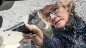 Frau kratzt Eis von Autoscheibe. | Es bleibt in Kärnten und Osttirol bis nächste Woche frostig.