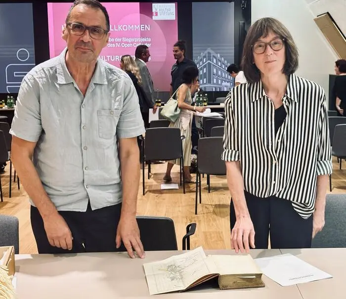 Nicole Six und Paul Petritsch mit dem Buch, in dem die historische Karte des Franz-Josef-Lands mit der Insel Klagenfurt abgebildet ist