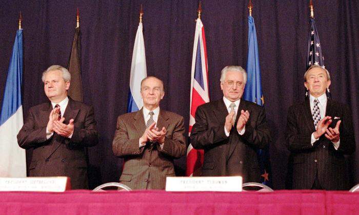 Serbiens Präsident Slobodan Milosevic, Bosniens Präsident Alija Izetbegovic, der kroatische Präsident Franjo Tudjman und U.S. Außenminister Warren Christopher, von links, applaudieren nach der Einigung über einen Friedensvertrag am 21. Nov. 1995 auf dem Luftwaffenstützpunkt Wright-Patterson in Dayton, USA. Unterzeichnet wurde der Vertrag am 14. Dezember 1995 in Paris 