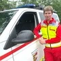 Ein junger Wasserretter steht neben seinem Einsatzfahrzeug
