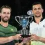 Croatia's Mate Pavic (R) and Austria's Oliver Marach hold the winners' trophy after beating Colombia's Robert Farah and Colombia's Juan Sebastian Cabal in their men's doubles final match on day 13 of the Australian Open tennis tournament in Melbourne early January 28, 2018. / AFP PHOTO / SAEED KHAN / -- IMAGE RESTRICTED TO EDITORIAL USE - STRICTLY NO COMMERCIAL USE --