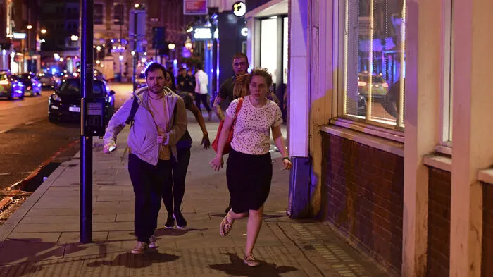 Passanten flüchten die Borough High Street entlang, während die britische Polizei die London Bridge sperrt.