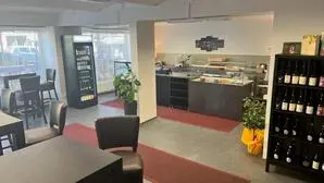 Eine Theke mit Feinkost und mehrere Tische mit Stühlen