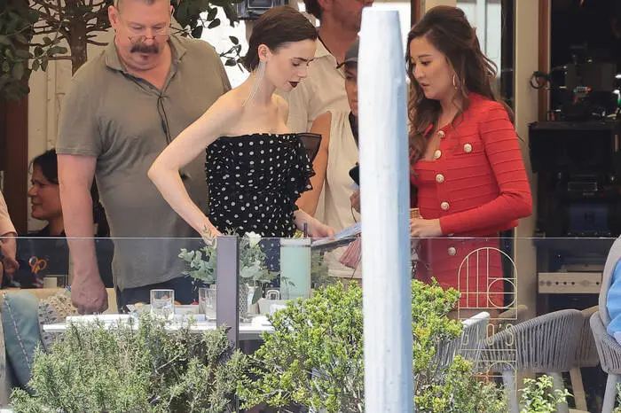 Der Stilfaktor bleibt hoch. Collins verzaubert im schwarz-weißen Pünktchen-Kleid, während Serien-Freundin Ashley Park im feurig-roten Outfit mit goldenen Knöpfen alle Blicke auf sich zog.