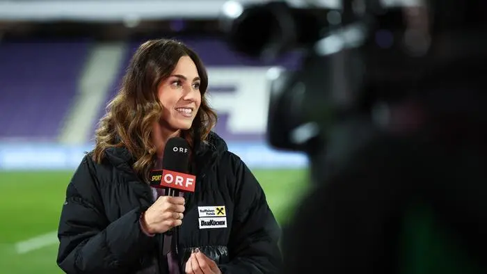 TV-Expertin Viktoria Schnaderbeck in einem Fußballstadion mit ORF-Mikrofon