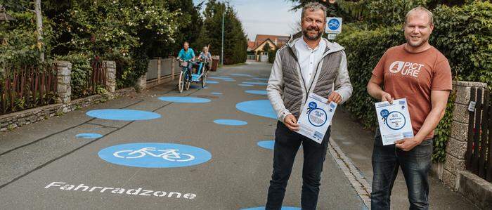 Sehen eine „Verbesserung für alle“: Bürgermeister Tulnik und der zweite Vize Ziegler in der Peter-Rossegger-Straße, einer von neun Fahrradstraßen in Fernitz-Mellach
