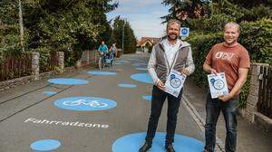 Sehen eine „Verbesserung für alle“: Bürgermeister Tulnik und der zweite Vize Ziegler in der Peter-Rossegger-Straße, einer von neun Fahrradstraßen in Fernitz-Mellach