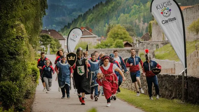 Eine Gruppe von mittelalterlich gekleideten Personen rennt Richtung Kamera