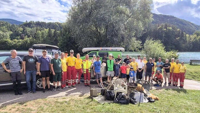 Gruppe von Personen stehn hinter Müllberg