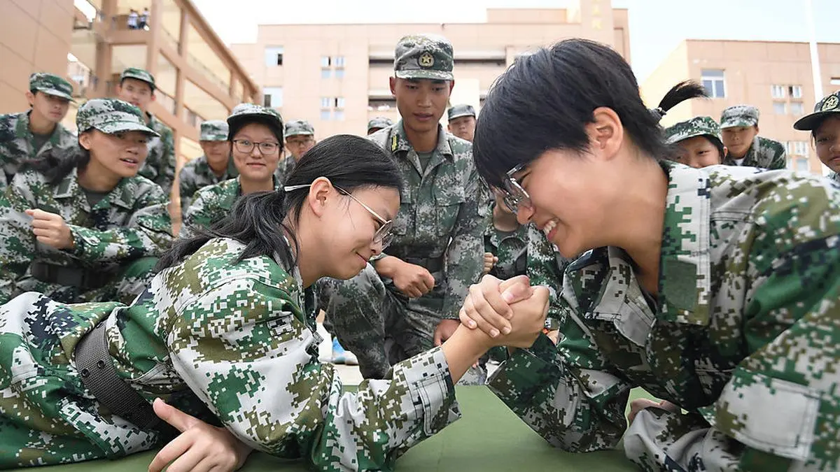 Hier alles nur Spaß. Armdrücken zweier chinesischer Studentinnen bei einer Militärübung in Guiyang