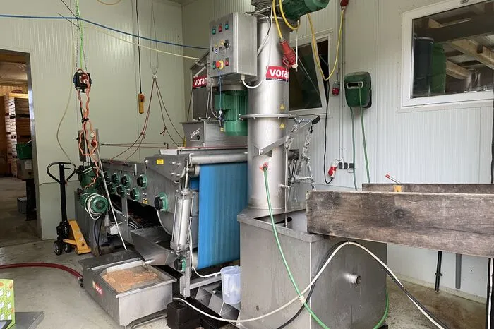 Im hinteren Teil steht die Apfelpressmaschine
