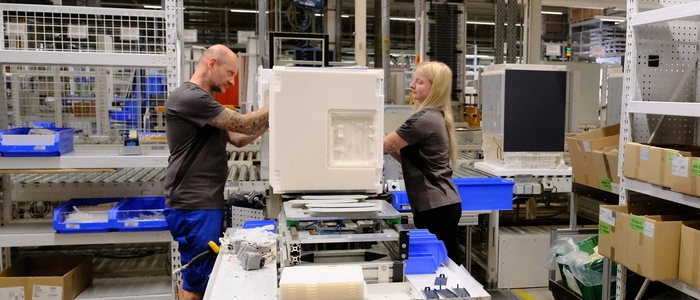Eine Mitarbeiter und ein Mitarbeiter von Liebherr bei der Montage eines Kühlschranks