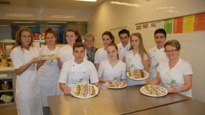 Nina Chiara, Lisa, Julia, Michael, Direktorin Rudolfine Praßl, Janine, Sarah, Marcel, Elisa, Chalil und Elisabeth Eder zeigen stolz die köstlichen Kekse