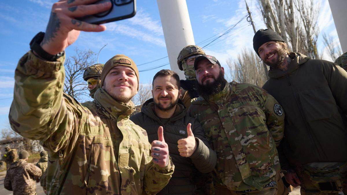Soldaten in der von der Ukraine zurückeroberten Stadt Cherson machen Selfies mit ihrem Oberbefehlshaber Wolodymyr Selenskyj.
