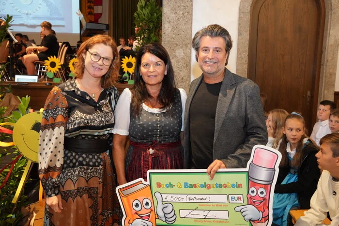 Stefan Sandrieser überreicht einen Bücherscheck an die Direktorin.