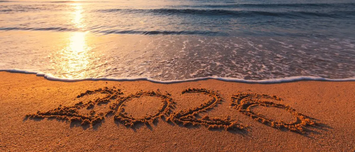 Happy New Year 2026 concept, lettering on the beach. Written text on the sea beach at sunrise.
