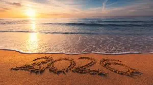 Happy New Year 2026 concept, lettering on the beach. Written text on the sea beach at sunrise.