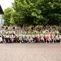 Viele Schüler und Lehrer auf einem Abschlussfoto mit Zeugnissen