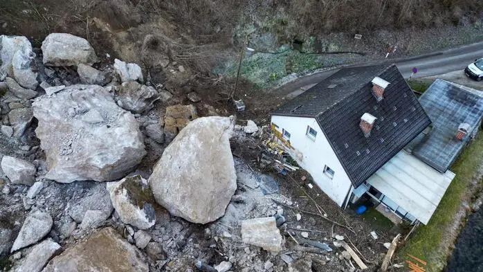 Ein Fels stürzt auf ein Haus