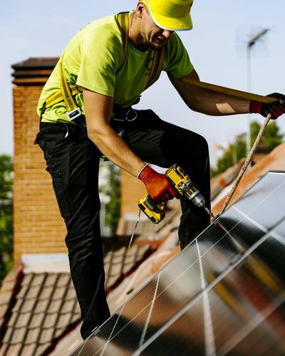 Engineer wearing hardhat using drill machine to install solar panel model released, Symbolfoto, JJF01138