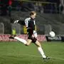 Ein Fußballer tritt einen Ball
