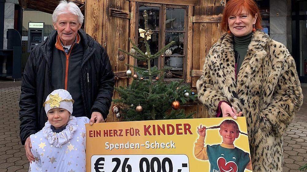 Viktor Plank, Enkelin Milena Plank und Brigitte Neubauer von der Kärntner Kinderkrebshilfe bei der Spendenübergabe für krebskranke Kinder am Neuen Platz in Spittal.