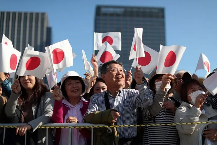 Dort wohnen Naruhito (59) und Masako (55) derzeit noch, bis der Kaiserpalast für sie umgebaut ist. Entlang der Straßen standen Zehntausende mit rot-weißen Fähnchen und jubelten.