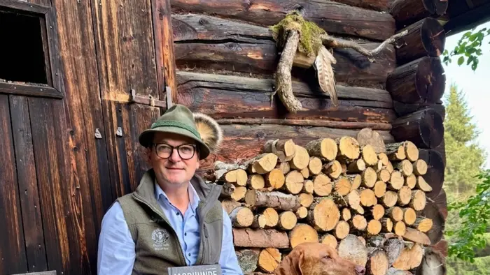 Bernhard Hammer mit seiner Jagdhündin Chaya, einer Magyar Vizsla-Dame, und dem von ihm verfassten Fachbuch