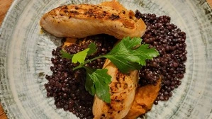 Maishendlbrust mit Kürbispüree und Beluga-Linsen.