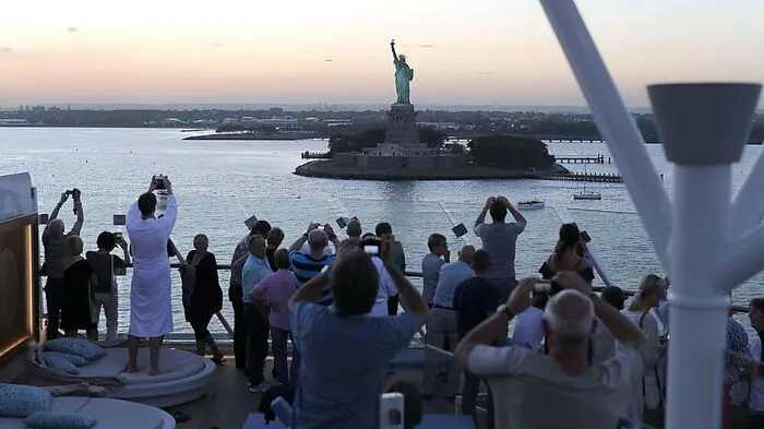 Als "Mein Schiff 6" von New York ablegt, drängen alle nach draußen für ein Foto der Freiheitsstatue - auch im Bademantel . . .