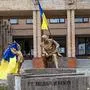 A photograph taken on September 10 , 2022, shows Ukrainian flags placed on statues in a square in Balakliya, Kharkiv region, amid the Russian invasion of Ukraine. - Ukrainian forces said on September 10, 2022 they had entered the town of Kupiansk in eastern Ukraine, dislodging Russian troops from a key logistics hub in a lightning counter-offensive that has seen swathes of territory recaptured. (Photo by Juan BARRETO / AFP)