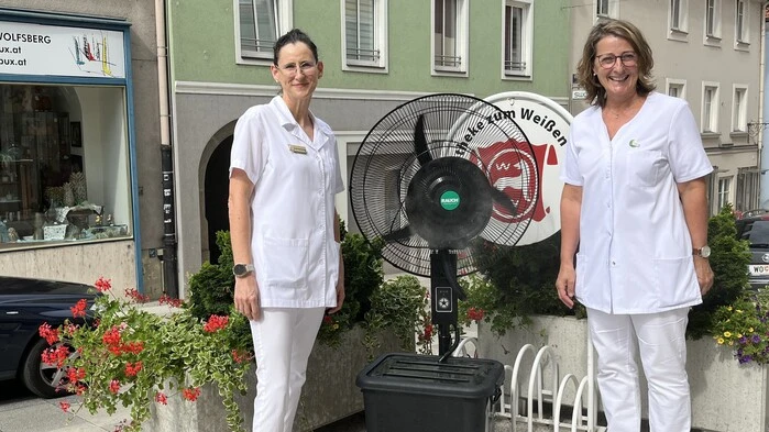 Die Mitarbeiterinnen Andrea Grassler und Elisabeth Hinteregger (von links) mit dem Sprühnebelventilator vor der Apotheke „Weisser Wolf“ am Hohen Platz in Wolfsberg