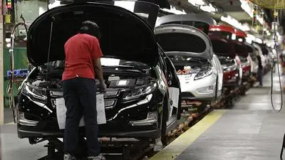 FILE- In this July 27, 2011, file photo, assembly worker Julaynne Trusel works on a Chevrolet Volt at the General Motors Hamtramck Assembly plant in Hamtramck, Mich. GM announced Monday, Nov. 26, 2018, that it will lay off thousands of factory and white-collar workers in North America and put five plants up for possible closure as it restructures to cut costs and focus more on autonomous and electric vehicles. Among the possibilities are the Detroit/Hamtramck assembly plant, which makes the Buick LaCrosse, the Chevrolet Impala and Volt, and the Cadillac CT6, all slow-selling cars. (AP Photo/Paul Sancya, File)