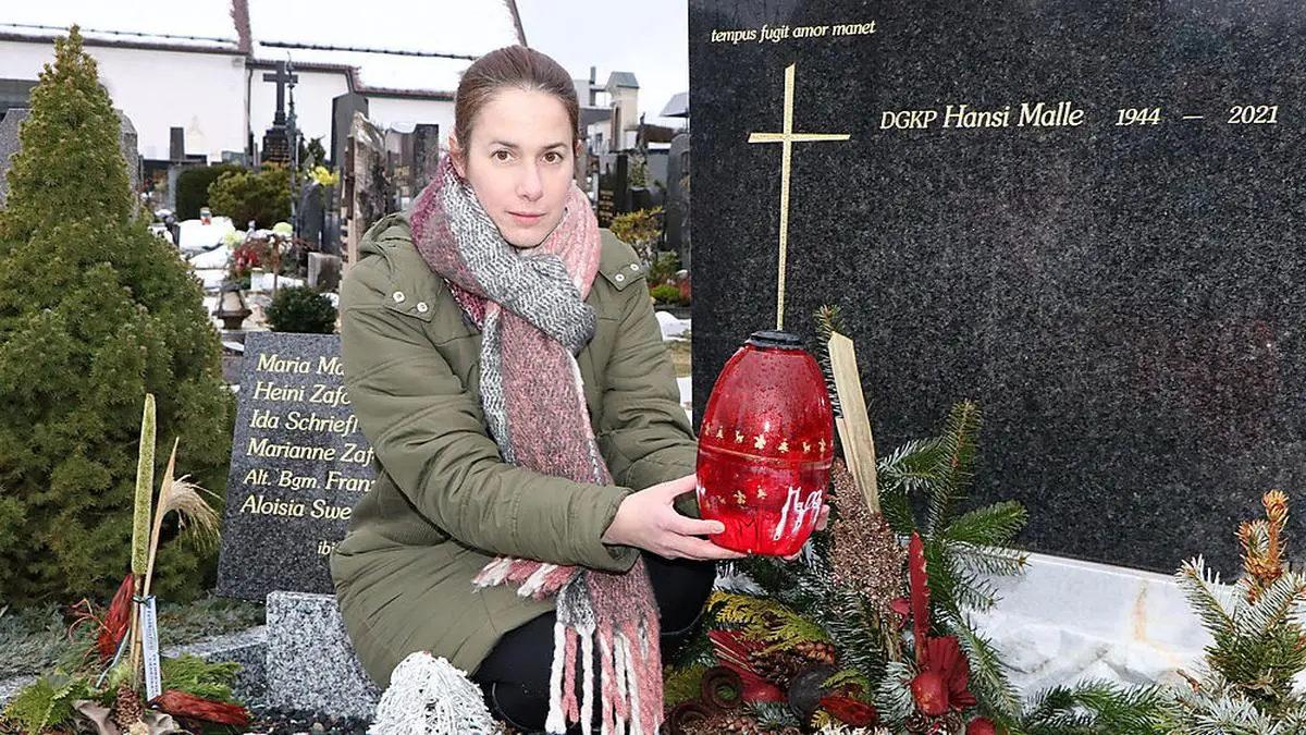 Alexandra Malle mit Öllampe beim Grab ihres Vaters