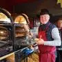 Ein Standler auf dem Lienzer Adventmarkt holt frisches Brot aus dem Ofen
