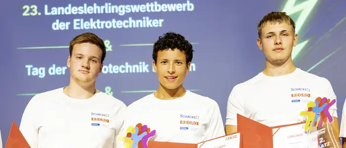 Drei junge Menschen stehen auf einem Podest