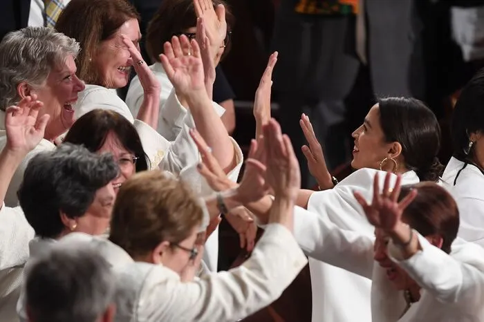 Die Frauen im Kongress kamen in Weiß und erinnerten an die weiß gekleideten Aktivistinnen, die vor 100 Jahren in den USA das Wahlrecht erkämpften.  Als Trump die Rekordzahl von Frauen im neu gewählten Kongress würdigt - vile von ihnen Gegnerinnen von Trump - springen sie auf und jubeln.