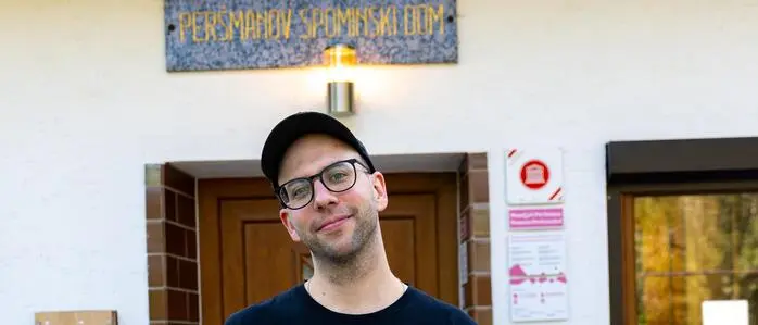 Gönitzer mit schwarzem T-Shirt, Kappe und Brille vor dem Museum