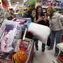 FILE - In this Nov. 28, 2014, file photo, Target shoppers Kelly Foley, left, Debbie Winslow, center, and Ann Rich use a smartphone to look at a competitor's prices while shopping shortly after midnight on Black Friday, in South Portland, Maine. Stores have been pushing deals on holiday merchandise throughout November, but they’ll be stepping it up for the official holiday kickoff, the busiest days of the year. 2017 has been a tough year in retail, with many store closures and some bankruptcies. But with unemployment low, stores are hoping customers are in a mood to shop. (AP Photo/Robert F. Bukaty, File)