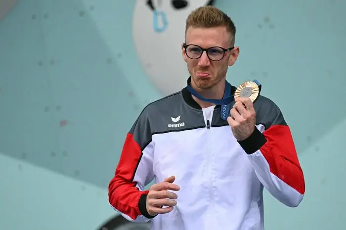 Austrian bronze medalist Jakob Schubert poses on the podium after the men's sport climbing lead final during the Paris 2024 Olympic Games at Le Bourget Sport Climbing Venue in Le Bourget on August 9, 2024. (Photo by Fabrice COFFRINI / AFP)