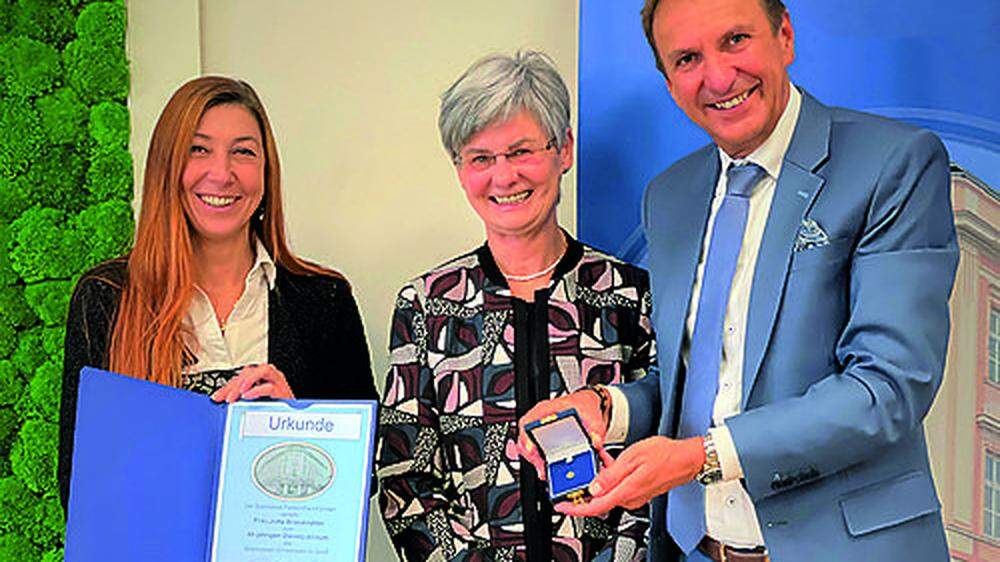 Vorstandsdirektor Gerhard Greimer und Betriebsratsvorsitzende Monika Seidl überreichten Jutta Brandstätter (Mitte) eine Urkunde und die Sparkassen-Ehrennadel in Gold