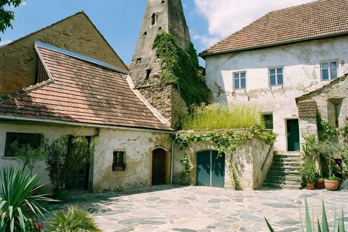 "Das beste Haus Niederösterreichs" ist 2018 ein denkmalgeschützter Gutshof aus dem 13. Jahrhundert, der stufenweise revitalisiert und mit viel Geschick und Sensibilität auf zeitgemäßen Wohnstandard gebracht wurde. Für die Planung zeichnet der Architekt Franz Sam verantwortlich. Die Jury erklärt: "Konsequente Trennung zwischen Alt und Neu macht die Historie des Bauwerks in allen Phasen erkennbar, Materialwahl und Formensprache zeigen, dass Anbiederung an alte Bausubstanzen nicht notwendig ist. Im Gelenk des L-förmigen Grundrisses befinden sich die bequeme Treppe und ein Lift, Elemente wie Fenster und Türen wurden erhalten und von innen thermisch aufgewertet. Die hermetische Fassade blieb unverändert, vorhandene Öffnungen sind durch gekonnte Neuinterpretation wirkungsvoll inszeniert. Strategisch eingesetzte Lichtgaupen im Dach, gezielte Lichtführung, Glasböden und Galerien sorgen für helles, wohnliches Ambiente. Der dreistöckige Gutshof beherbergt nach Abschluss der 3. Bauphase drei Generationen einer Familie in insgesamt vier Wohneinheiten. So kann die Integration zeitgemäßer Nutzungsszenarien in historisch gewachsenen Besiedlungsstrukturen funktionieren!"