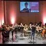Ein Orchester aus jungen Musikerinnen und Musikern spielt auf einer Bühne